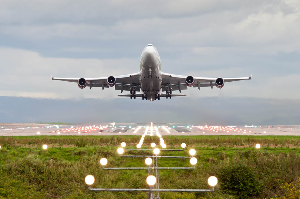 Plane taking off from Manchester Airport with landing lights